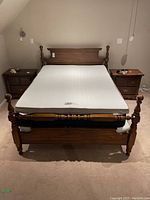 Front view of Kroehler queen wood bed frame with mattress on top