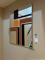 Front angle view showing the mirror and the retro design on it. Reflective sections show part of a staircase and walls.