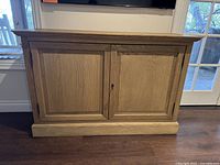 Front view of oak credenza with closed paneled doors and keyhole hardware