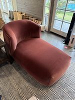 Overhead view showing chaise lounge shape at angle in room with patterned rug and pillows behind