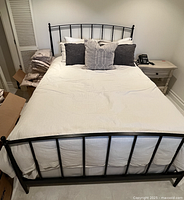 Assembled queen bed frame and mattress with bedding