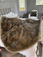 Photo of the faux fur throw blanket spread out on a bed showing the fur texture and color variation.