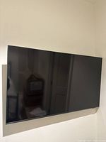 Wall-mounted TV showing front panel and bezel