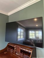 Front view of the wall-mounted Samsung TV showing screen and bezel