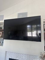 Wall-mounted Samsung flat screen TV above fireplace