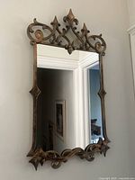 Full view of ornate metal framed wall mirror against wall