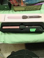 FOXYIVE curling iron in black and rose gold inside protective packaging box.