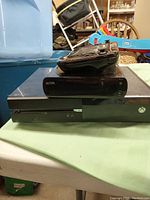Xbox 360 console stacked beneath Wii U console and Wii U GamePad on top