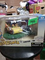 Front and side view of the sealed Flintstones at the Drive-In figurine set in box with green $75 price sticker.