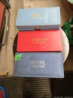 Three rectangular watch cases stacked, labeled MX West, Valencia Collection, and Royal Collection