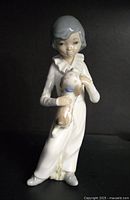 Front view of the Casades porcelain figurine showing the girl holding her dog