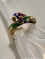 Front view of coiled snake ring showing head, open mouth and enamel detailing