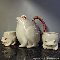Front view of frog pitcher and two mugs