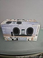 Photo of the speaker dock box showing product image, brand name Hip Street, and usage information including compatibility and range.