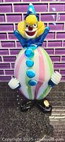 Front view of the Murano clown figurine with neon yellow, blue, pink, and green colors.