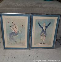 Photo of two framed Robert Weil drawings side by side, showing their size, colors, and matching frames.