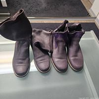 Two pairs of purple Roots boots displayed side by side showing the top and side profiles.