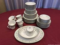 Full set of Noritake Spring Meadow dinnerware arranged showing plates, cups, bowls, and serving pieces.