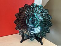 Full view of the Federal Glass teal blue petal bowl on display stand, showing flower petal edges and center flower motif pattern.