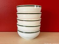 Stacked view of five vintage diner soup bowls showing exterior with colored stripes. Three bowls with red stripes, two with green stripes.