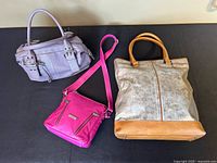 Three leather purses side by side on a flat surface, showing the front and top of each purse.