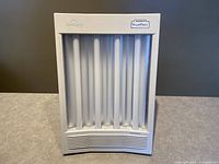 Front view showing the lamp with vertical fluorescent tubes behind white cover. Nature Bright and SunTouch labels visible.