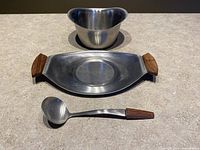 Sauce bowl, serving plate, and ladle spoon arranged separately to show individual items.