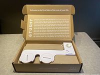 Top inside view of the open box showing the bidet attachment and control panel in molded cardboard packaging.