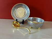 Set of bowl, plate, and ladle arranged with red background.