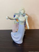 Porcelain Avon Good Fairy figurine decanter shown with delicate detailing and blue dress, taken from front angle.
