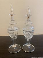 Front view showing pair of Egyptian hand blown glass bottles with decorative glass elements and stoppers.