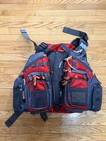 Front view of the adult fishing life preserver vest showing seven external zippered pockets and mesh detailing.