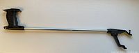 Full length view of reaching aid grabber tool showing metal shaft and handle with trigger