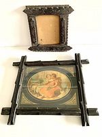 Two antique handcarved wooden frames side by side, one with an old print and the other empty