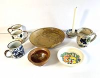 Full set of pottery and ceramic items showing large artisanal bowl, smaller bowl, three mugs, pet bowl, pitcher, and candle holder