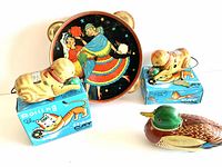 View of all toys including two rolling cat toys on original boxes and the metal tambourine decorated with flamenco dancers.