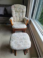 Full view of Dutailier solid wood glider rocker chair with matching foot rest upholstered in floral fabric.