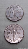 Photo showing reverse sides of 1944 and 1945 Canadian Victory Nickels with torch and maple leaf design.