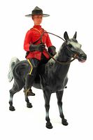 Front side view of the celluloid RCMP mountie figure on black horse, showing details of uniform, hat, reins, and horse's painted features.