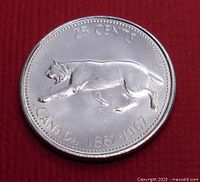 Reverse side of the 1967 Canadian 25 cent silver coin featuring a howling wolf, centennial dates and inscriptions