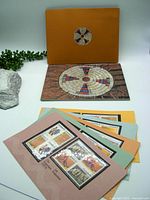 Five sheets with Indigenous culture themed Canadian stamps fanned in front of the yellow folder and booklet.