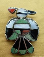Front view of the Thunderbird eagle pendant and brooch showing colorful inlays of turquoise, onyx, shell, and coral in sterling silver setting.