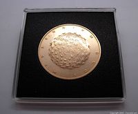 Obverse side of the bronze medallion showing dandelion head design with inscription 'MILLENNIUM 2000'