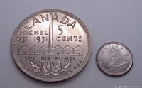 Photo showing 1951 Canadian 5 cents coin alongside dime for scale, highlighting the size difference and design details.