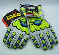 Front view of leather work gloves showing blue and green impact protection pads and attached product tags including BDG and 3M labels.