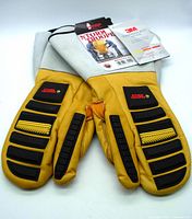 Top view of pair of yellow leather one-finger mitts with black rubber padding, white cuffs, and attached product tags.
