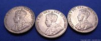 Obverse view of three King George V 5 Cents Canadian coins dated 1922, 1930, and 1931