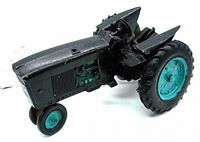 Side view of repainted black vintage metal toy tractor, showing paint wear and diecast details