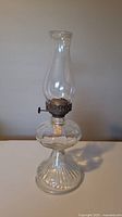 Full view of the antique oil lamp assembled with glass chimney.