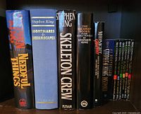 Overview of Stephen King hardcover and paperback books on shelf including Needful Things, Nightmares & Dreamscapes, Skeleton Crew, The Bachman Books, Midnight Graffiti, Insomnia and The Green Mile volumes